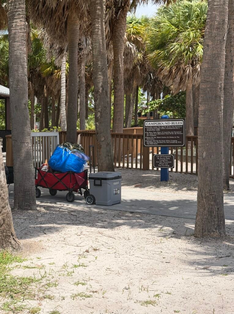 Campground Rules sign at the campground entrance, with a loaded beach wagon and cooler