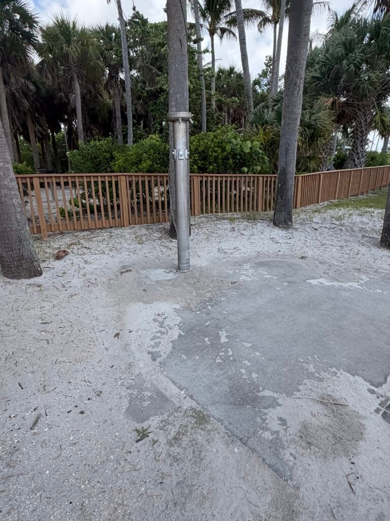 Outdoor rinse-off shower along the path beside the Peanut Island campground fence